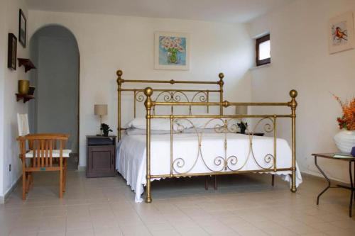 Villa gli Ulivi - Fivizzano في فيفيزانو: غرفة نوم بسرير وطاولة وكرسي
