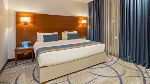 a bedroom with a large bed in a room at Jiwar Almasi Hotel in Jeddah