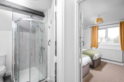 Well Coach House by Cliftonvalley Apartments في بريستول: حمام مع دش ومرحاض وسرير