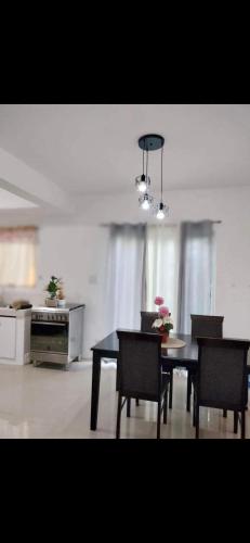 a dining room with a table and chairs and a kitchen at Vacation home in Lancaster new city Cavite Philippines in General Trias
