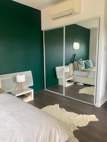 オービエールにあるChambre d'hôtes THE YELLOW CUBEの緑の壁と鏡が備わるベッドルーム