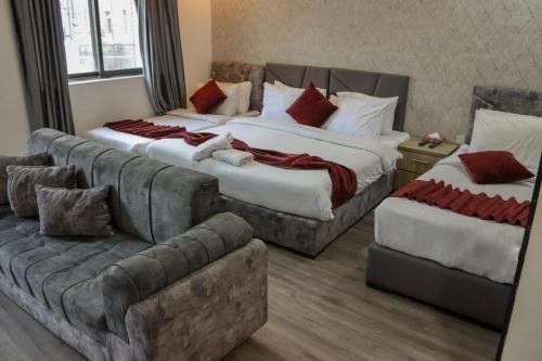 Twins Downtown Hotel في عمّان: غرفة فندقية بسريرين واريكة