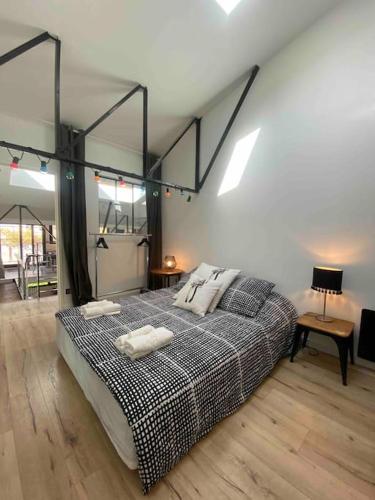 une chambre avec un lit avec deux oreillers dessus dans l'établissement Rare ! LOFT Atypique Centre-Ville Parking Jardin, à Reims