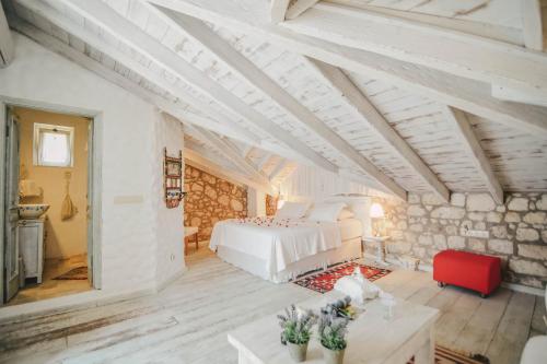 a bedroom with a white bed and a red chair at YUKARI SOKAK VİP BUTİK OTEL in Alacati