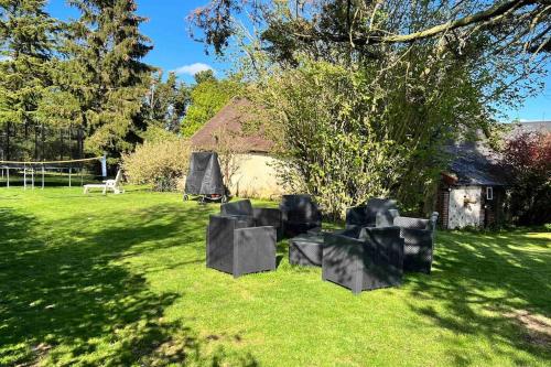 un groupe de chaises noires assises dans l'herbe dans l'établissement Maison piscine famille nombreuse 13 couchages, à Écublé