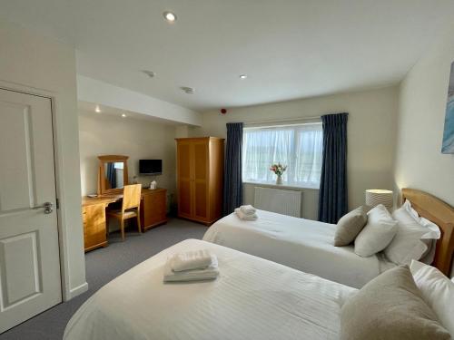 Pokój hotelowy z 2 łóżkami i biurkiem w obiekcie Cosy room with golf & the beach on your doorstep! w mieście Mawgan Porth