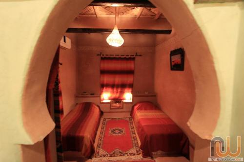 a room with two beds and a window at Riad Tamdakhte in Aït Ben Haddou