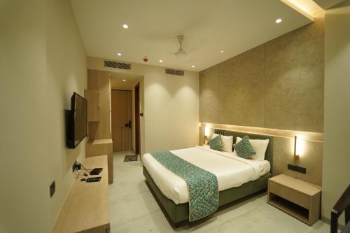 una camera d'albergo con letto e TV di HOTEL LAKSH a Raipur