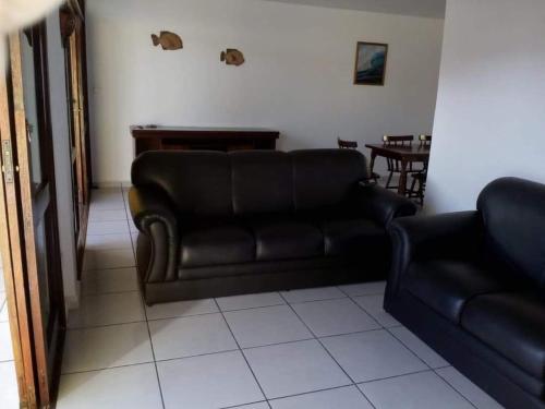 un soggiorno con divano in pelle e tavolo di Casa para alugar a Guarujá