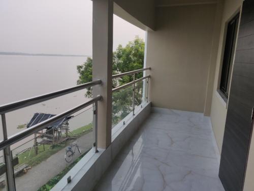 a room with a balcony with a view at ICHHAMATI HOTEL AND RESTAURANT in Hāsnābād