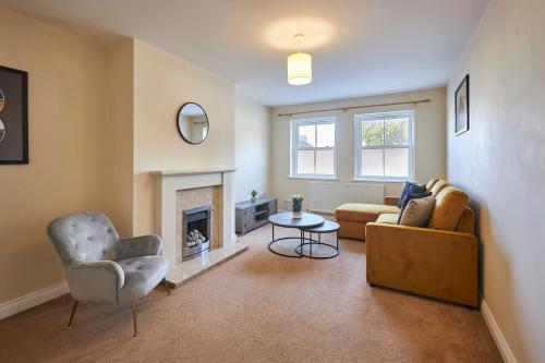 a living room with a couch and a fireplace at Host & Stay - Tibshelf House in Tibshelf