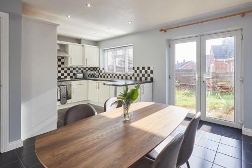 a kitchen with a wooden table and chairs at Host & Stay - Tibshelf House in Tibshelf