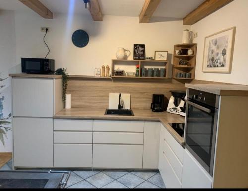 a kitchen with white cabinets and a stove top oven at Moarhof Ferienwohnung1 in Dietramszell