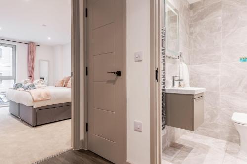 a bathroom with a toilet and a sink and a bed at Once Upon a Tide in Poole