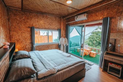 1 dormitorio con cama grande y ventana grande en CR farm stay ซีอาร์ฟาร์มสเตย์ 