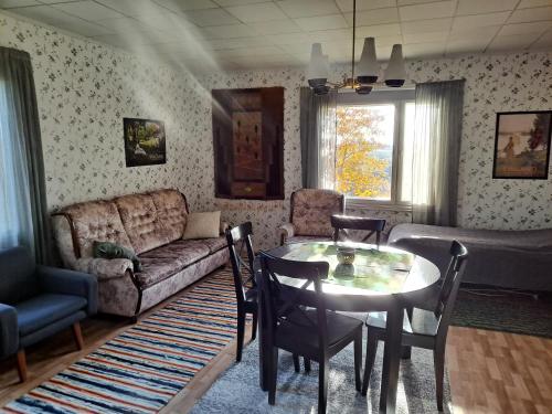 a living room with a table and a couch at Levomäki Farm Cottages in Ypäjä