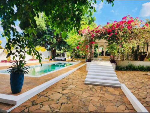 a house with a swimming pool with pink flowers at Killi Bohemian Luxury in Moshi