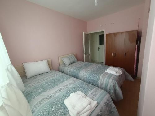 Duas camas num pequeno quarto com paredes cor-de-rosa em Hatice em Istambul