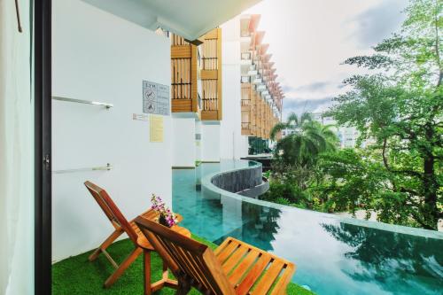 a balcony with two chairs and a swimming pool at The Lunar Patong in Patong Beach
