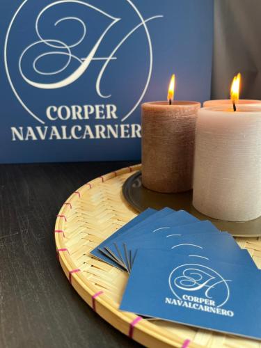 two candles and a paper napkin on a table with a sign at Hostal Corper Navalcarnero in Navalcarnero