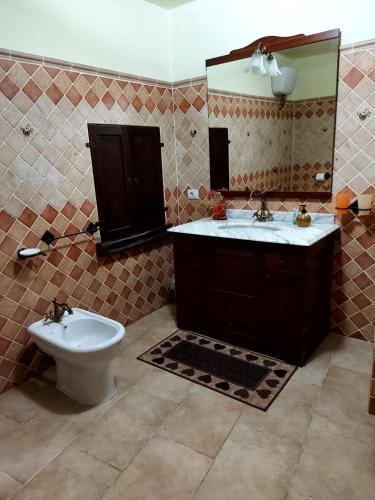 y baño con lavabo, aseo y espejo. en Sardinia House, en Villamassargia