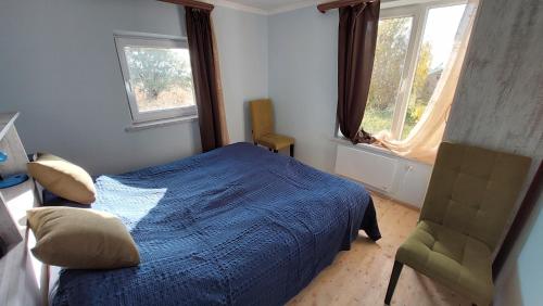 sypialnia z łóżkiem i krzesłem oraz 2 oknami w obiekcie Geghama Resort and Tours w mieście Geghard