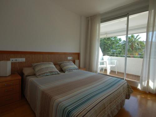 a bedroom with a bed and a large window at Lets Holidays Tossa de Mar Ancora in Tossa de Mar