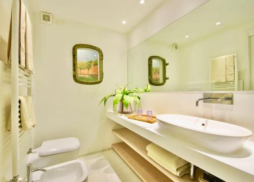 bagno bianco con lavandino e specchio di SUITE DOLCEVITA by KlabHouse a Zoagli