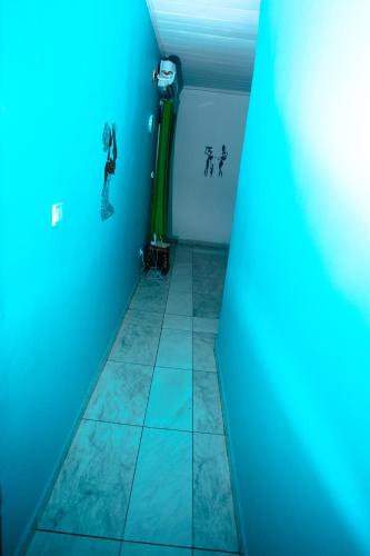 a blue room with a hallway with a tiled floor at Appartement Meublé Bonamoussadi Douala in Deido