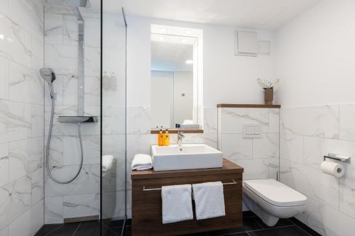 a bathroom with a sink and a toilet and a shower at The Doorman Goethe Frankfurt am Main in Frankfurt