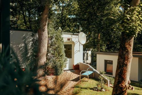 a small white house with a blue chair in a yard at Paulshöhe in Waren