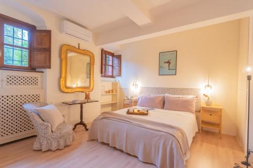 1 dormitorio con cama, espejo y silla en La Piazza di Cernobbio by Rent All Como, en Cernobbio