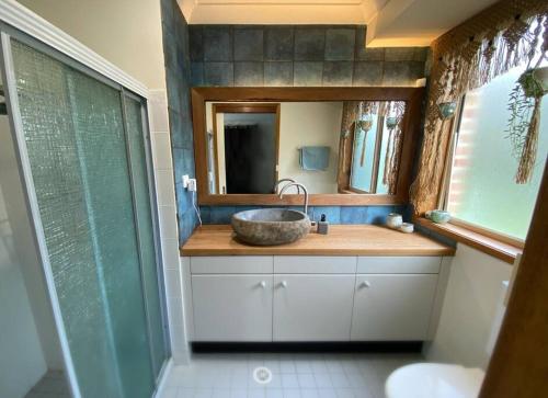 a bathroom with a sink and a mirror at Family home, close to beach and town in Moruya Heads