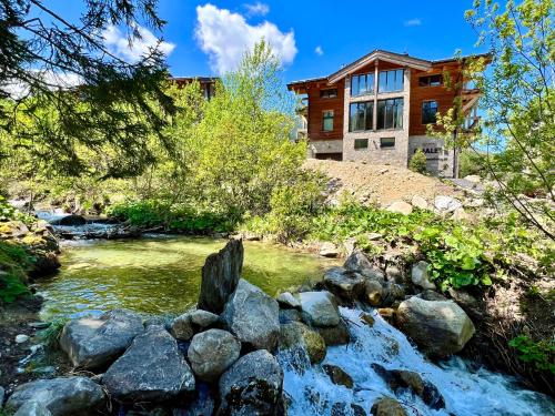 a river with rocks in front of a house at Chalet One Jasná in Demanovska Dolina