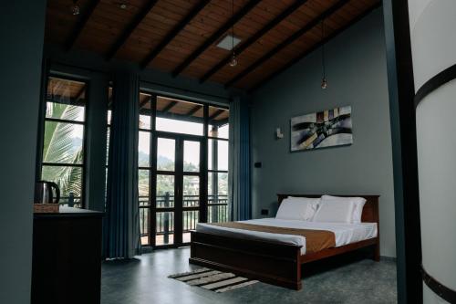 Un dormitorio con una cama con paredes y ventanas azules. en Amanzi Residence, en Kandy