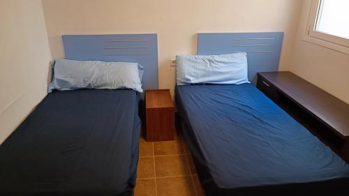 2 camas en una habitación con sábanas y almohadas azules en Beachhouse, Beautiful space, beautiful sea view, on the beach, en Cartagena