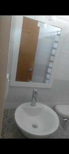 a white sink in a bathroom with a mirror at GARZOTA SUITE DEL ARTE 3er Piso in Guayaquil