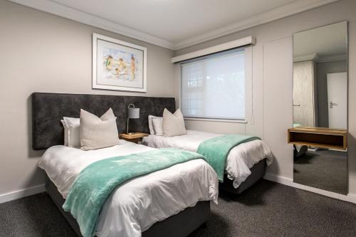 a hotel room with two beds and a window at Bayview 104 in Hermanus