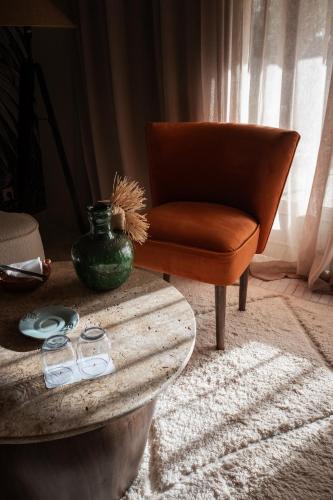 a living room with a chair and a table at Domaine Des Remparts Hotel & Spa in Marrakech