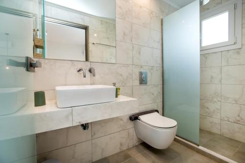 a bathroom with a toilet and a sink and a mirror at Agali Rooms in Skala Rachoniou