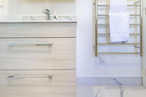 a bathroom with wooden drawers and a sink at Serenity Getaway in Christchurch