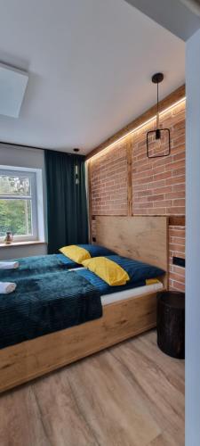 a bedroom with a large bed and a brick wall at Apartament LuxLoft2 in Piechowice