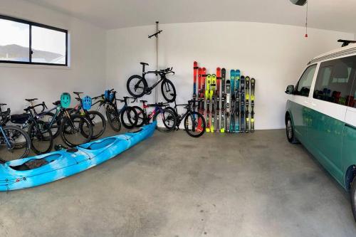 a group of bikes parked in a garage next to a bus at Jindabyne house 1, Modern 1 bedroom home, alpine views & fireplace in Jindabyne