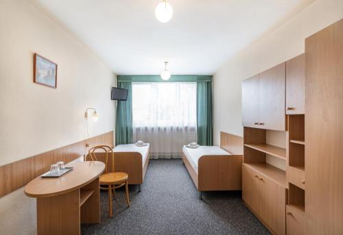 a hospital room with a bed and a table at Hotel Alf in Kraków