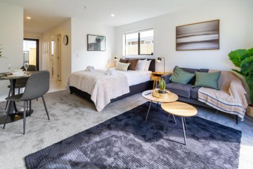 Habitación de hotel con cama y sofá en Serenity Getaway, en Christchurch