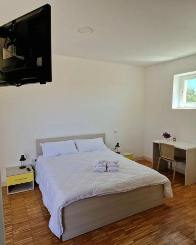 una camera con letto, TV e scrivania di Bisus de Jara a Tuili