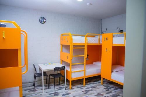 Habitación con 2 literas y mesa. en City Hostel Shymkent, en Shymkent