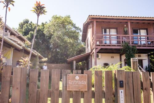a wooden fence in front of a house at Kanaloa Vibe Stay in Praia do Rosa
