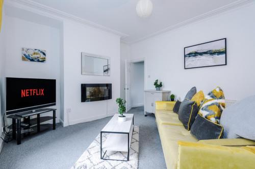 a living room with a yellow couch and a tv at Long term offers Message for prices Sleeps 6 Adults, Contractors, Relocators, Travellers in Halifax