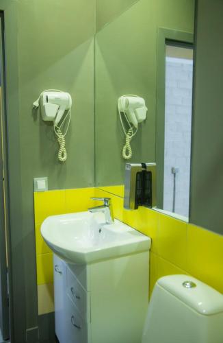 a bathroom with a sink and a toilet and a mirror at City Hostel Shymkent in Shymkent